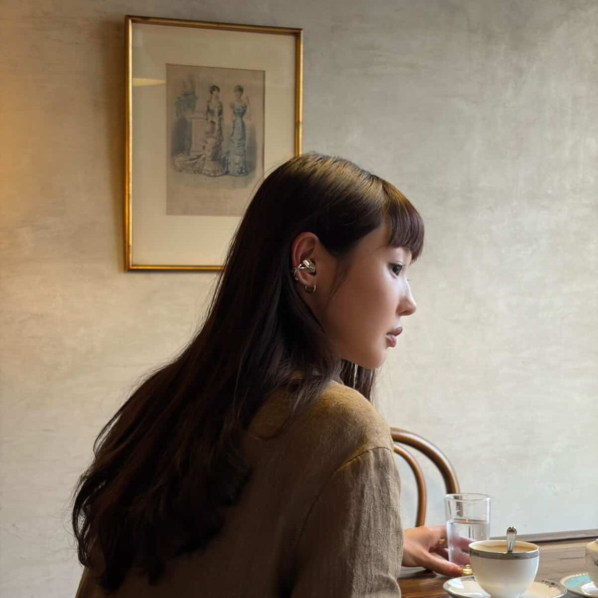 Electronic Gems worn at a cafe table with a brown jacket.