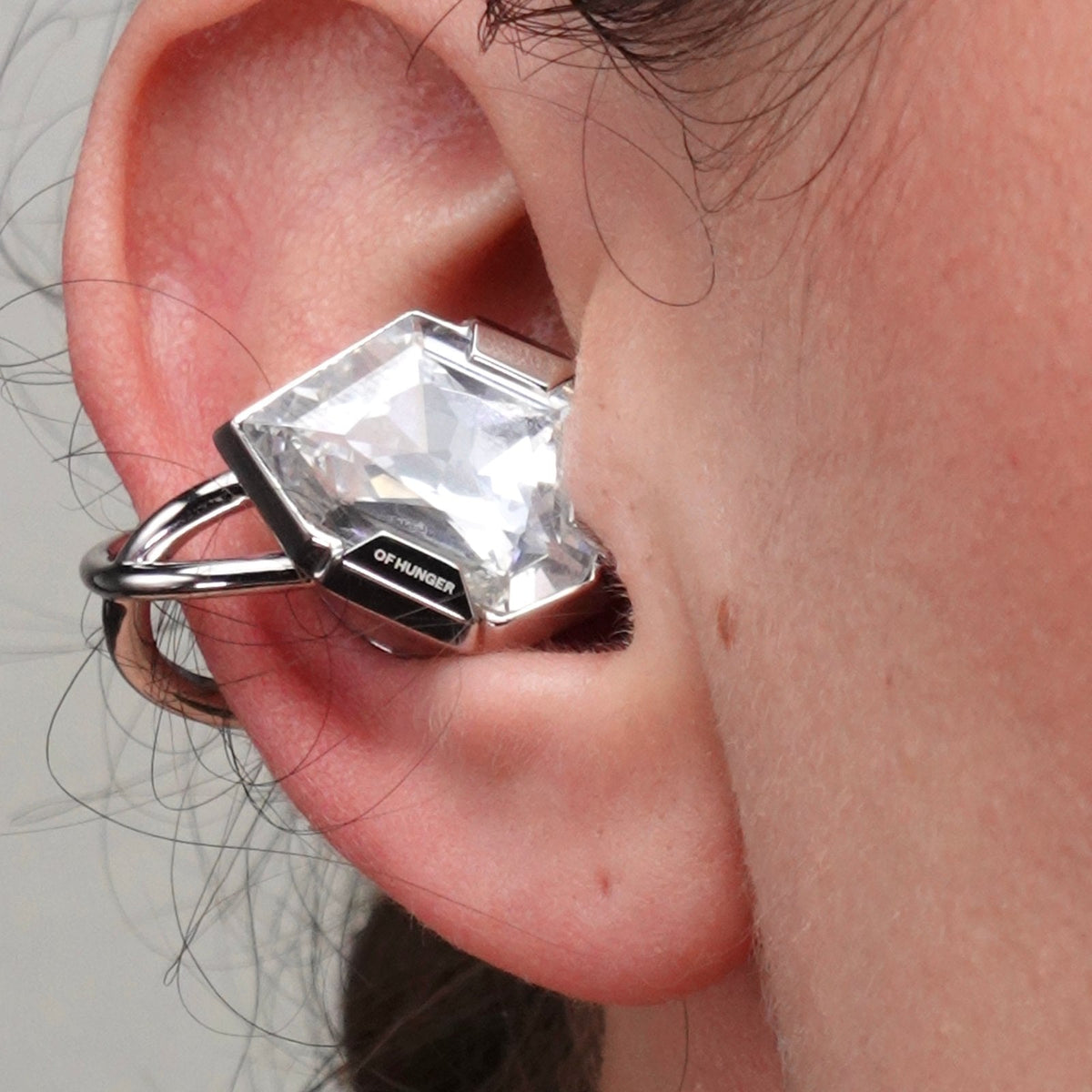 Close-up of an Electronic Gems ear clip resting around the outer ear.