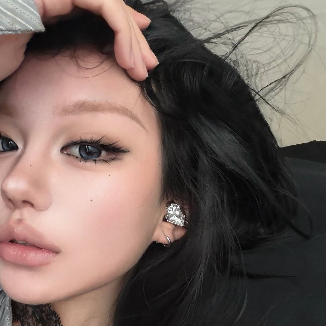 Close portrait showing an Electronic Gems ear clip beside dark hair.