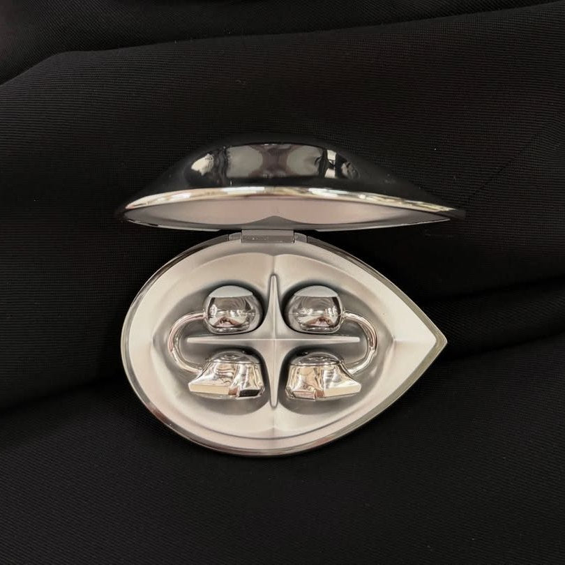 An open Electronic Gems charging case with both earphones inside, resting on black fabric.