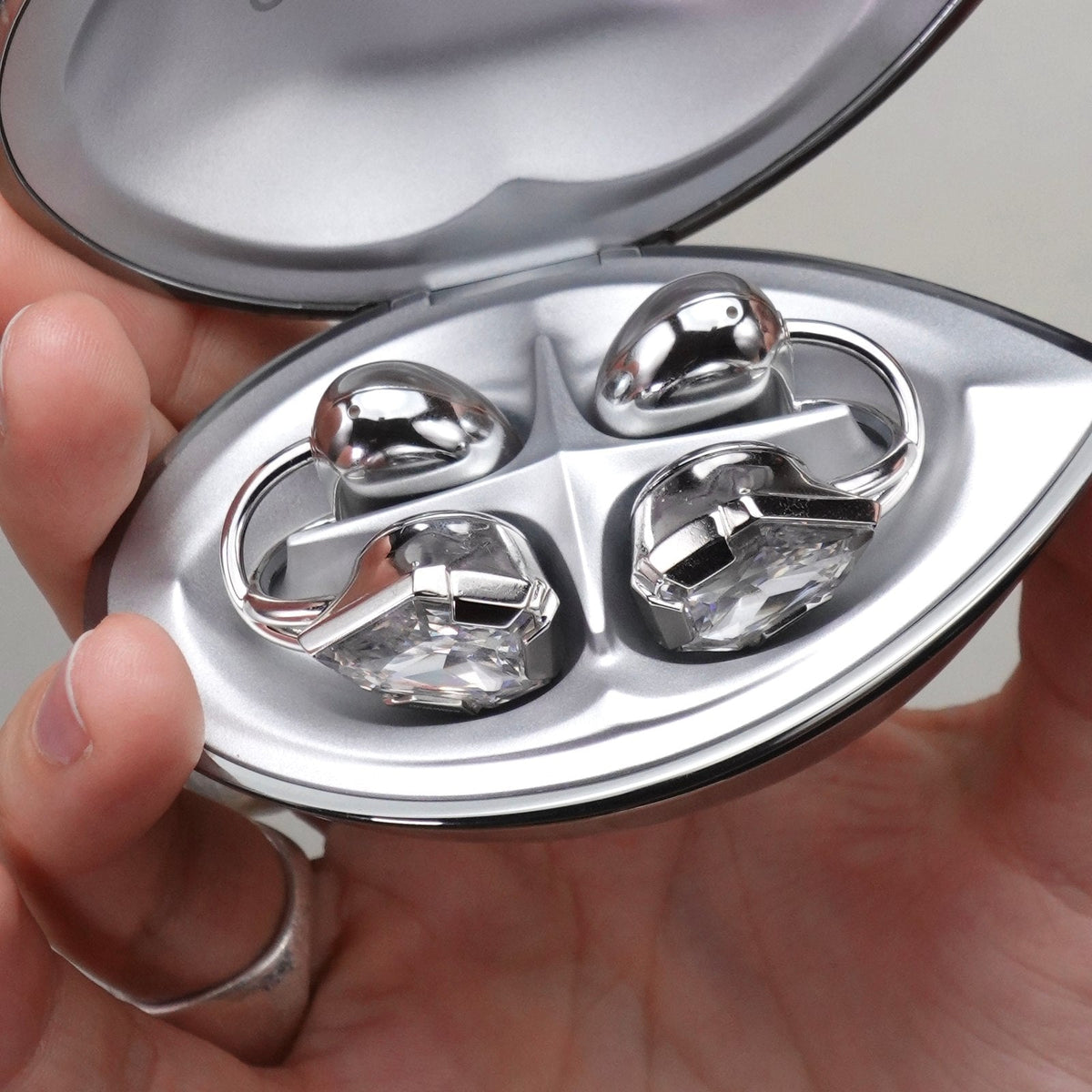 Close-up of the decorative Electronic Gems faces seated in an open charging case.