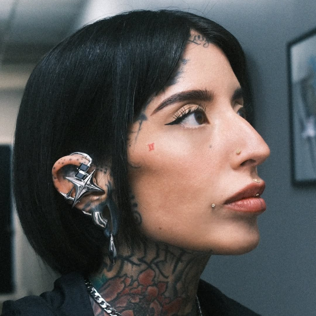 Silver-toned NEBULA ear-hook earphones paired with a black collar and chain necklace.