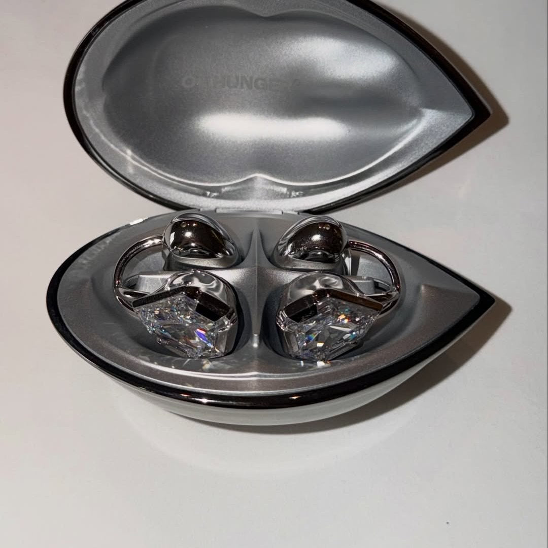 An open Electronic Gems charging case with both earphones inside against a light background.