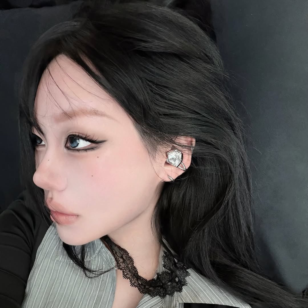 Electronic Gems worn in profile with a gray collar and a black lace necklace.