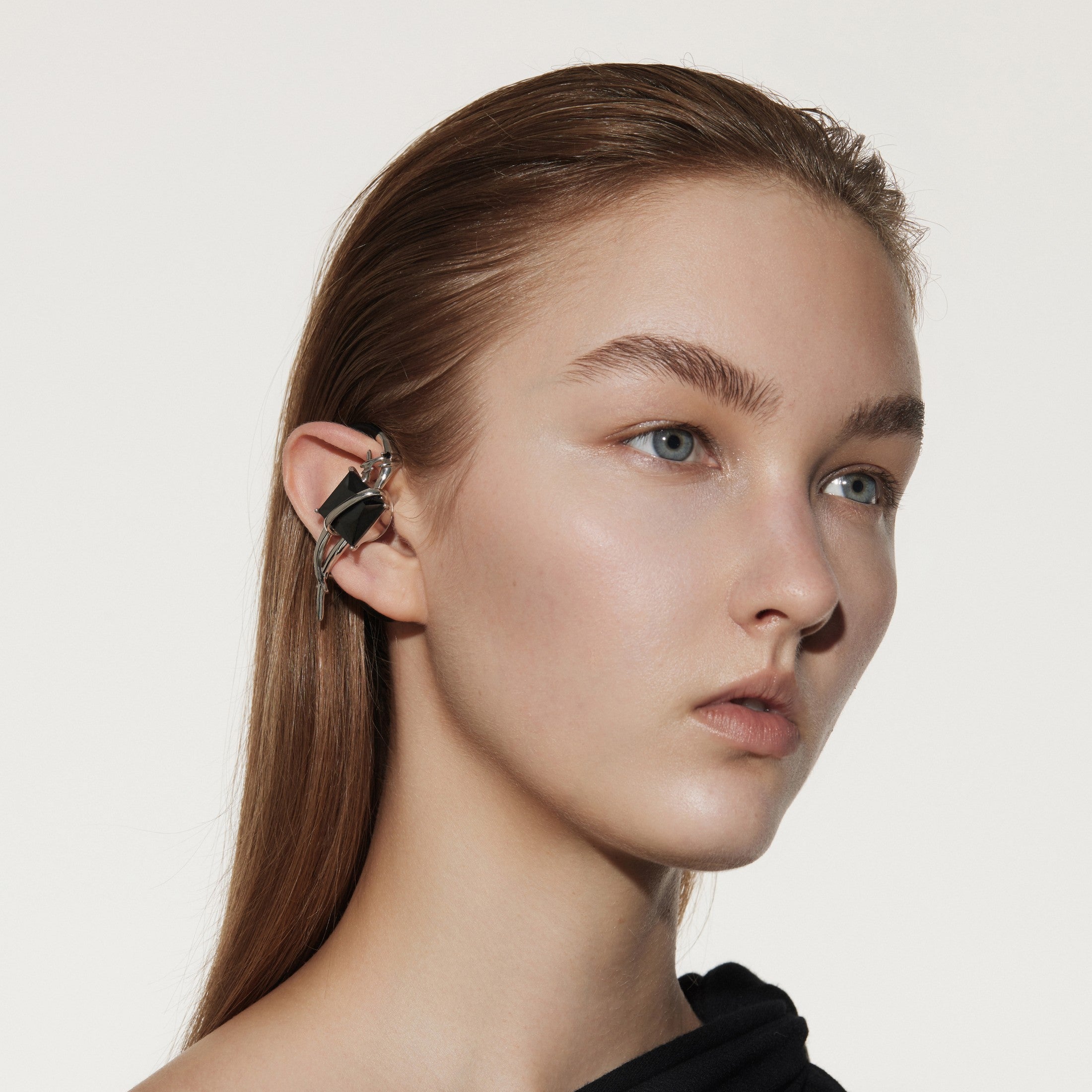 Futuristic OF HUNGER black stone earphones styled for a cyber post-human aesthetic