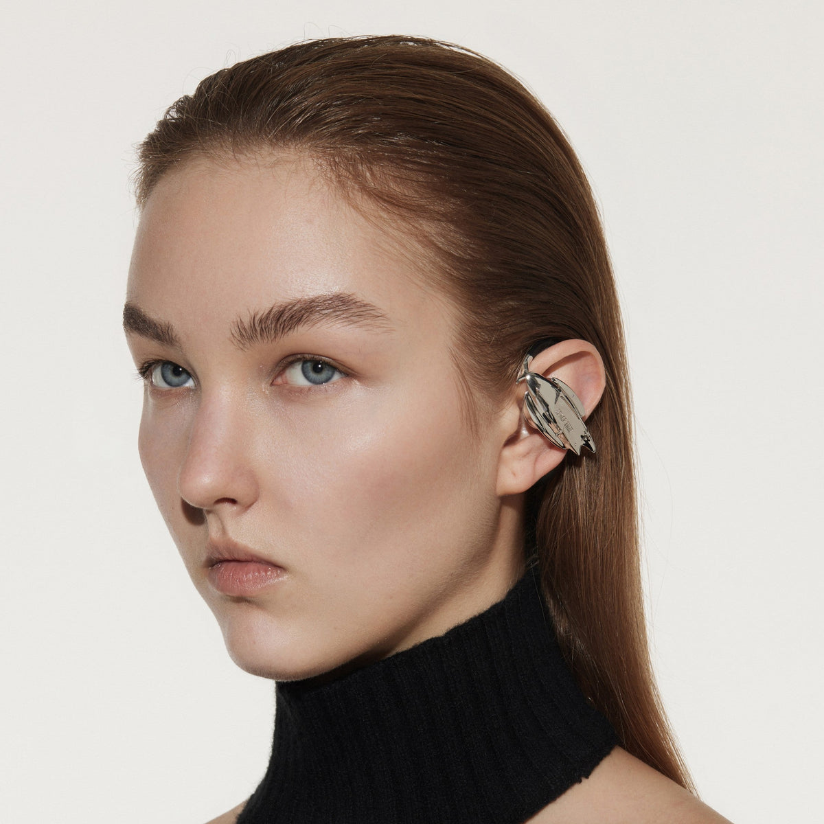 Model wearing OF HUNGER GALAXY earphones with a restrained silver futuristic silhouette