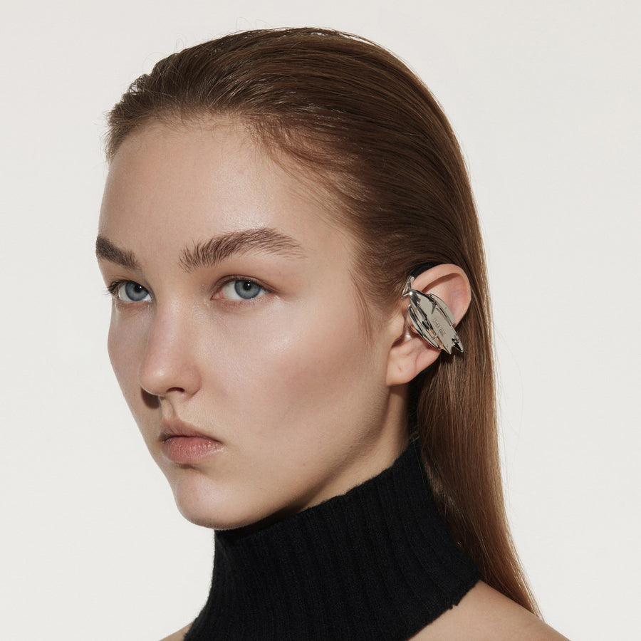 Model wearing OF HUNGER GALAXY earphones with a restrained silver futuristic silhouette