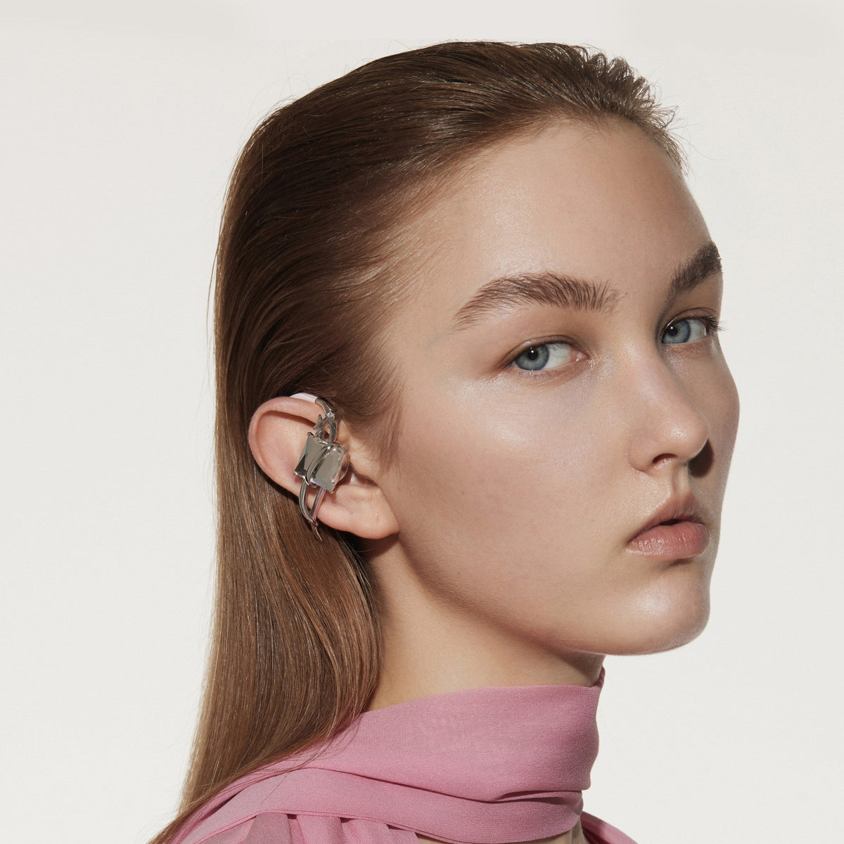 Close model styling with OF HUNGER White Stone earphones treating the ear as a visual canvas