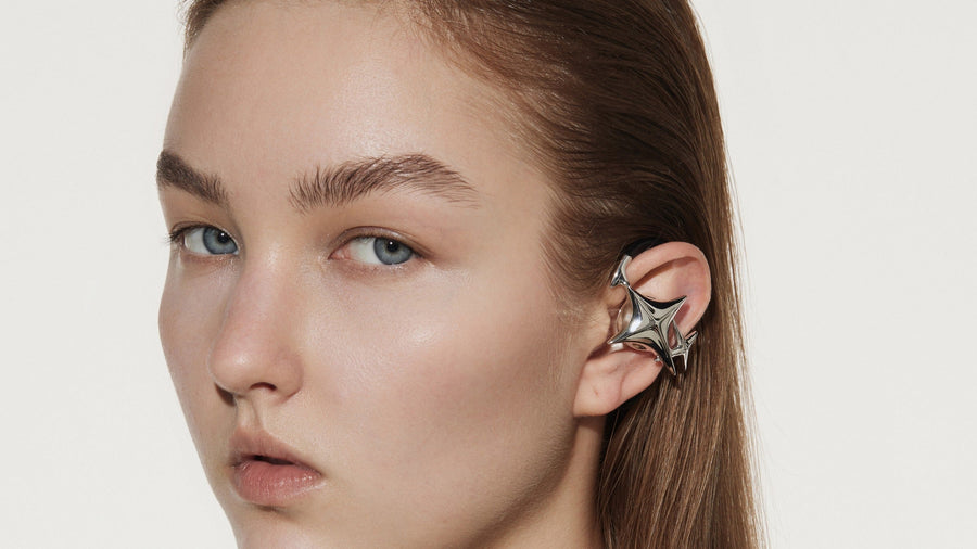 Model wearing OF HUNGER open-ear ear cuff headphone in a clean editorial close-up